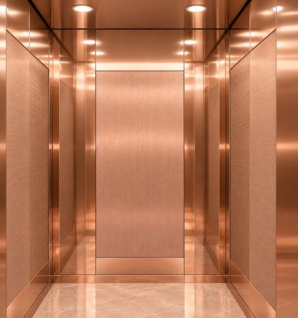 Rose Royale cabin: rose gold hairline panels framed in rose gold mirror, rose-beige marble floor