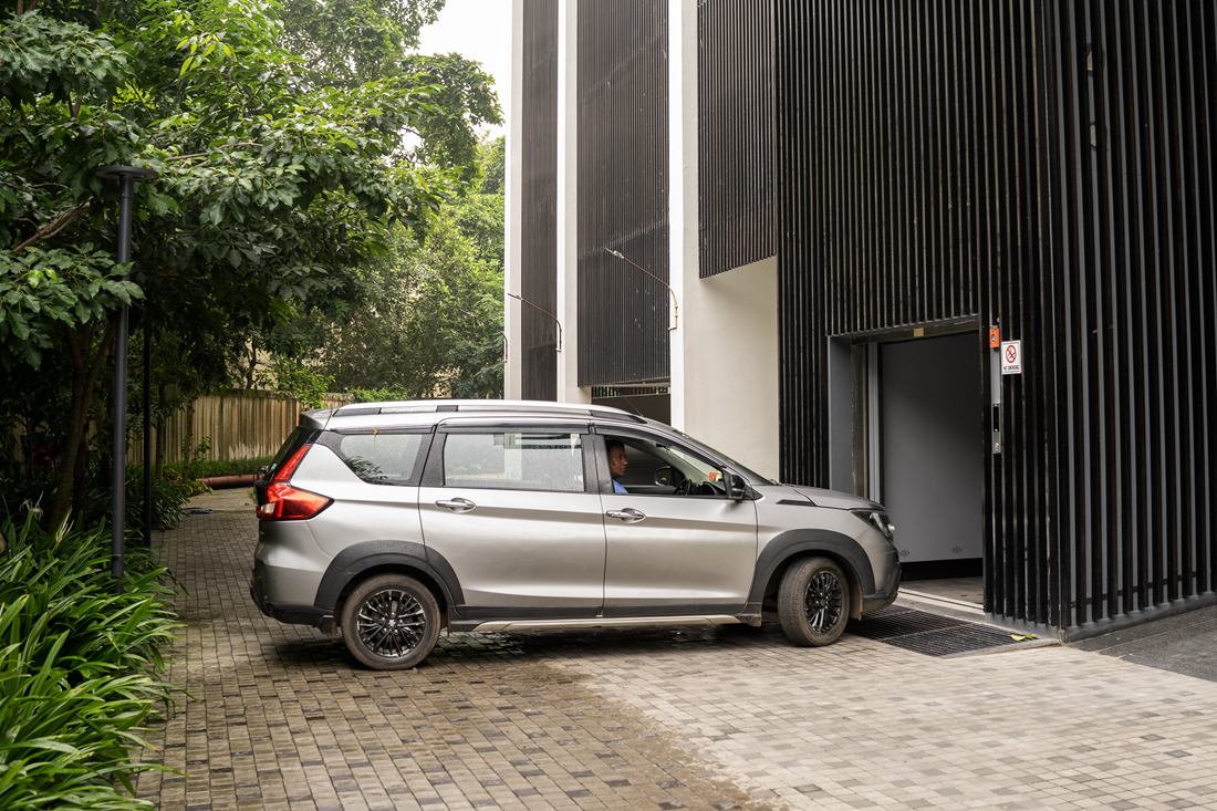 SUV driving into a car lift set in a slatted façade