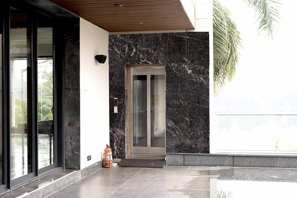 Terrace lift framed by dark marble cladding
